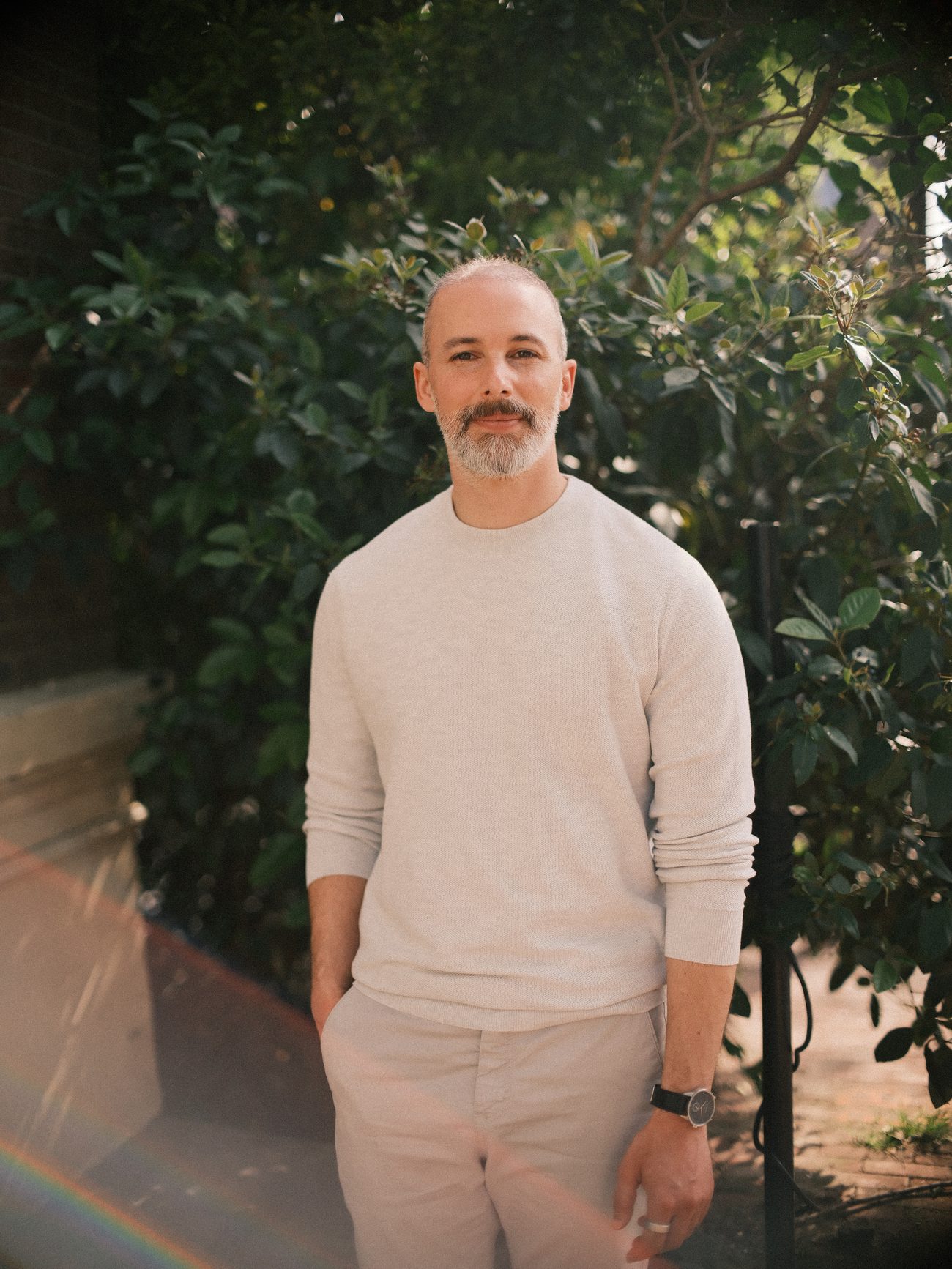 Michel Guerreiro, coach and founder of Inner Lab Coaching, standing among green leaves